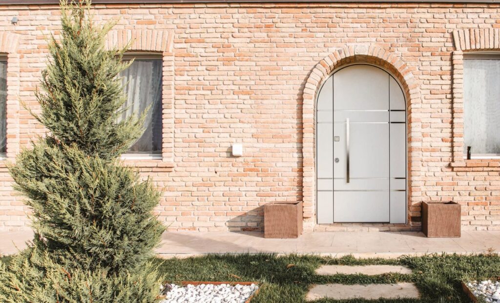 Porta blindata ad arco su casa in mattoni