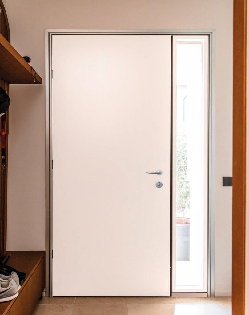 Porta blindata in alluminio bianca in un ingresso moderno