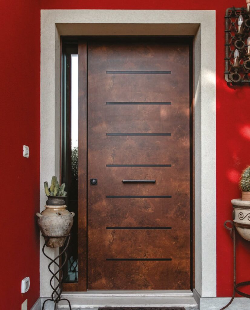 Porta blindata in alluminio scura su parete rossa