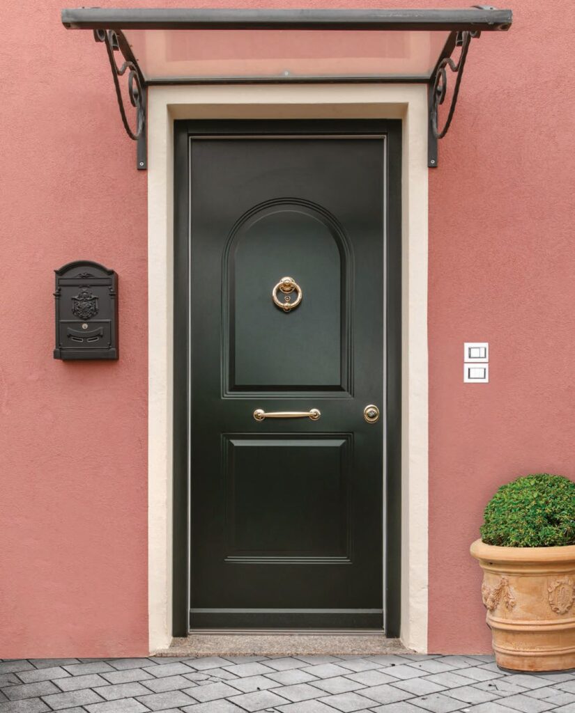 Porta blindata classica verde su facciata rosa