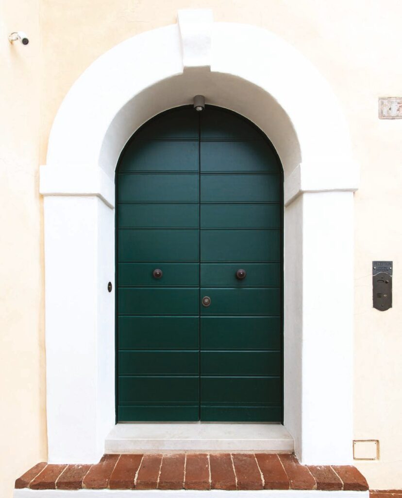 Porta blindata ad arco verde in un portale storico