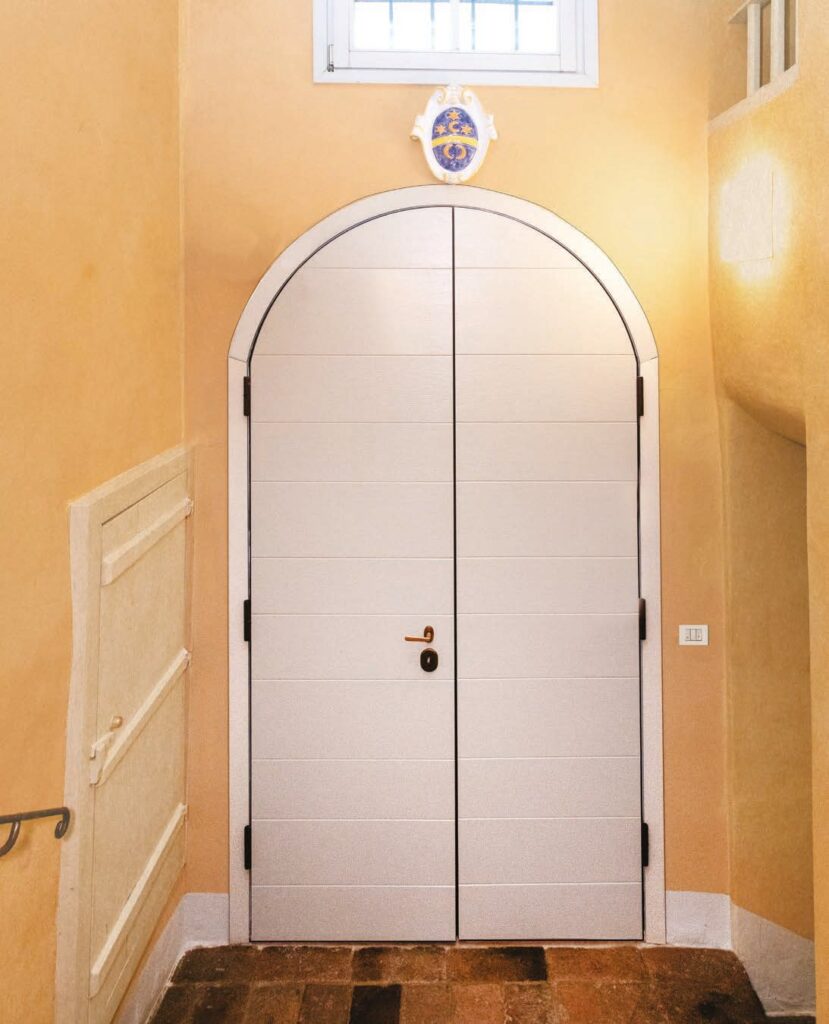 Porta blindata bianca ad arco in un interno