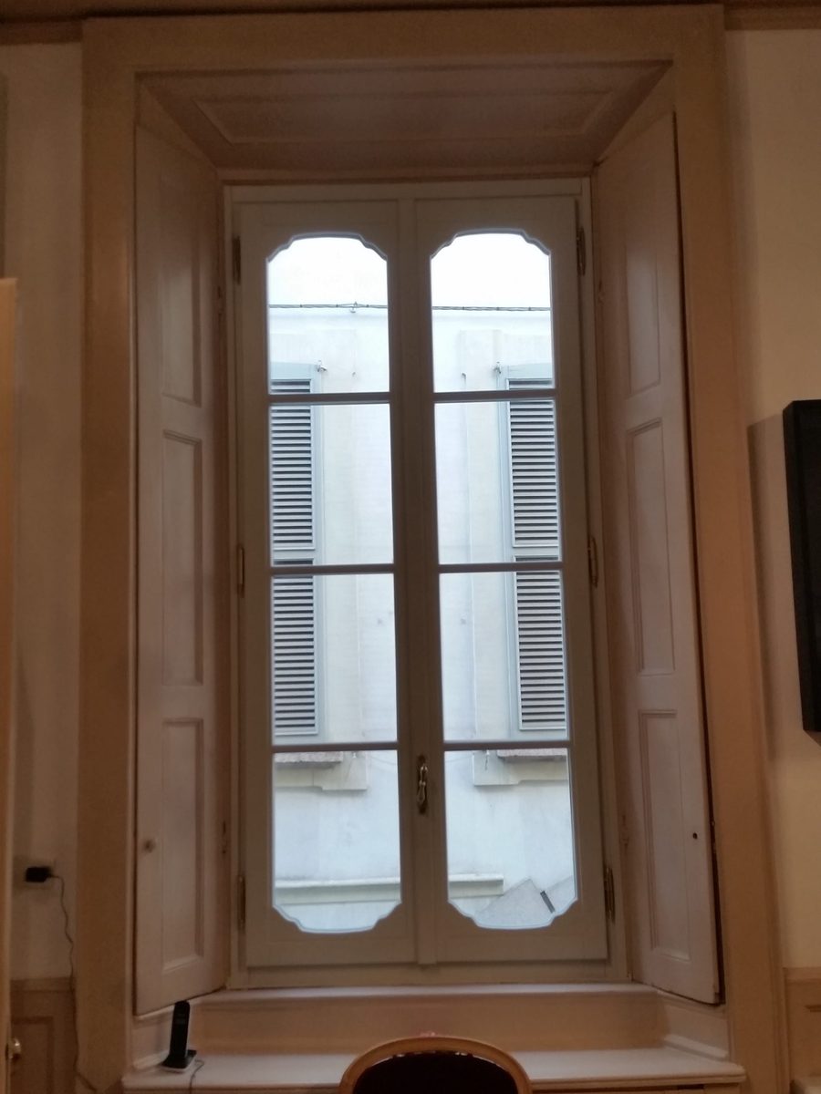 Finestra in legno con inglesine e scuri interni in un palazzo d'epoca